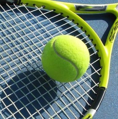 Tennis racquet and ball on court